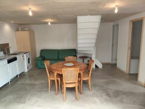 a living room with a table and a green couch at Penty vue sur mer in Tréguennec