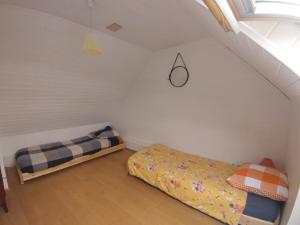 a attic room with two beds and a window at Penty vue sur mer in Tréguennec
