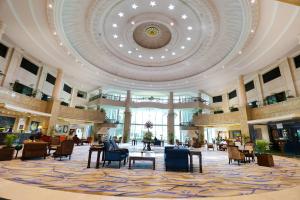a lobby with chairs and tables and a ceiling at Le Royal Meridien Chennai in Chennai