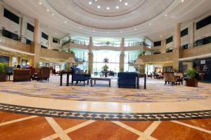 a lobby with chairs and tables in a building at Le Royal Meridien Chennai in Chennai +143 photos