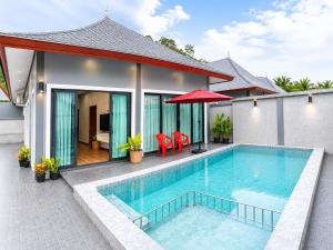 a swimming pool in front of a house at Villa Escape Aonang Krabi in Krabi