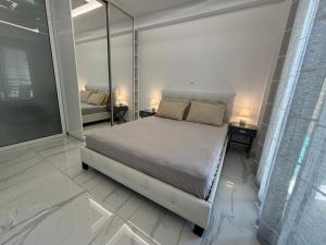 a bedroom with a bed and two lamps on tables at The Onyx Residence in Loutraki
