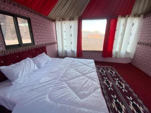 a bedroom with a large white bed with windows at Salem Wadi Rum Road in Wadi Rum