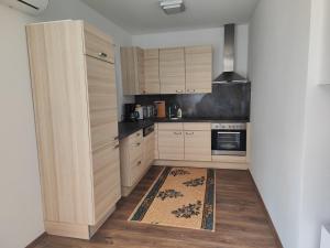 a kitchen with wooden cabinets and a rug on the floor at Kata 2 in Ližnjan