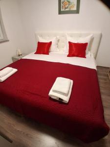 a large red and white bed with red pillows at Kata 2 in Ližnjan