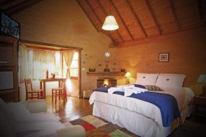 a bedroom with a bed and a table and chairs at Pousada Canto da Lua in São Bento do Sapucaí