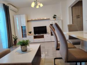 a living room with a table and chairs and a television at Apartman David in Senj