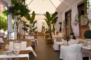 a restaurant with white tables and chairs and plants at Hotel Metropole Venezia in Venice