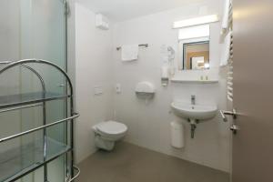 a white bathroom with a toilet and a sink at NEKA Village in Balatonboglár +25 photos