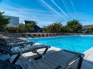 a swimming pool with chaise lounge chairs next to it at Sud Ocean J N74 2P4 in Guidel +6 photos