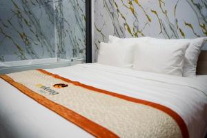 a white bed with an orange and white blanket on it at Mekong Hotel in Tây Ninh +54 photos