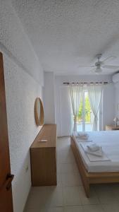 a bedroom with a bed and a table and a window at Bright & Bloom maisonette in Hanioti