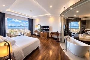a hotel room with a large bed and a bath tub at Sai Gon Ha Long Hotel in Ha Long