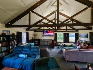 a living room with a large blue couch and chairs at Zula Lodge in Wanaka