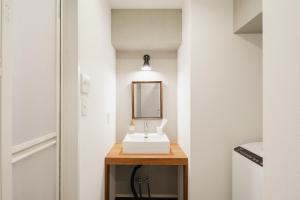 a bathroom with a sink and a mirror on a table at HIT Tenjin in Fukuoka