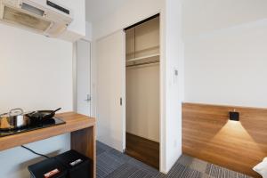 a small kitchen with a counter and a closet at HIT Tenjin in Fukuoka
