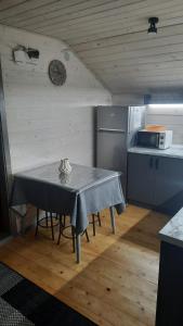 a kitchen with a table and a clock on the wall at Garage Home in Yaremche