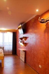 a living room with a tv on a wall at BoutiqueHotel KAPUZINERGARTEN in Breisach am Rhein