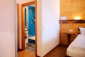 a room with a bed and a bathroom with a shower at BoutiqueHotel KAPUZINERGARTEN in Breisach am Rhein +77 photos
