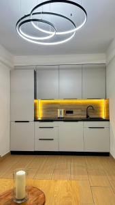 a kitchen with white cabinets and a large chandelier at Costa Blanca Międzyzdroje - Holiday Home in Międzyzdroje