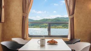 a table with a plate of croissants and a window at Taean Bibi ArtGlamping in Taean