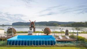 a house with a windmill and a swimming pool at Taean Bibi ArtGlamping in Taean
