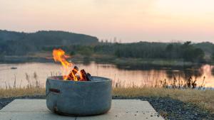 a fire pit sitting next to a body of water at Taean Bibi ArtGlamping in Taean +1 photo