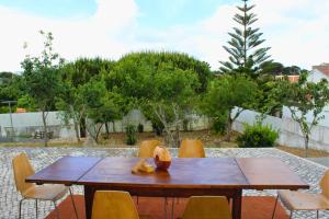 a wooden table with chairs in a yard at Villa Penim - Countryside Villa with Jacuzzi, Garden with BBQ & Stunning Views in Sesimbra