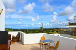 a patio with a table and chairs on a balcony at Villa Penim - Countryside Villa with Jacuzzi, Garden with BBQ & Stunning Views in Sesimbra
