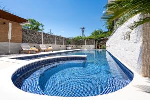 a swimming pool in a yard with two chairs at Villa D Apartments in Podlastva