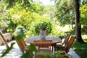 a wooden table with chairs and a vase on it at Villa D Apartments in Podlastva