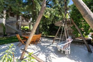 a swing in a yard with a table and chairs at Villa D Apartments in Podlastva