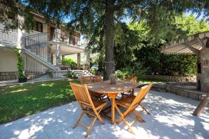 a wooden table and chairs in a yard at Villa D Apartments in Podlastva