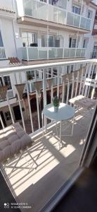 a balcony with a table and chairs on a building at Davinia apartamento centro in Nerja