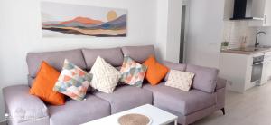 a living room with a couch with pillows on it at Davinia apartamento centro in Nerja