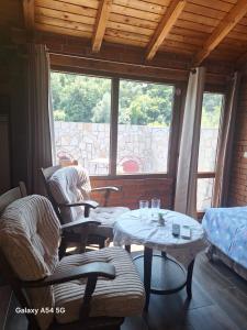 a room with two chairs and tables and a window at Coastalguest House in Veliko Tŭrnovo