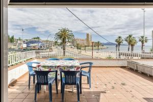 a table and chairs on a balcony with a view of the ocean at Apartamento Girelle in L'Escala