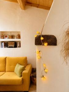 a living room with a yellow couch and lights on the wall at Casa de Benavila in Benavila +48 photos