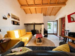 a living room with a yellow couch and a fireplace at Casa de Benavila in Benavila