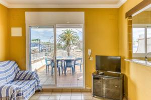 a living room with a couch and a table with chairs at Apartamento Girelle in L'Escala