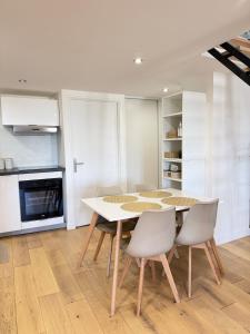 a kitchen and dining room with a table and chairs at Douceur Suite - 2 bedrooms in Mâcon +8 photos