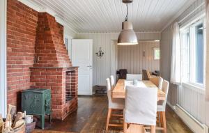 a dining room with a table and a brick wall at Uplandhytta in Ringsaker