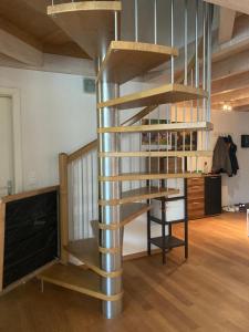 a spiral staircase in a room with a desk at Attic Family Room Mountain & Lake View - 2nd floor in Vinelz
