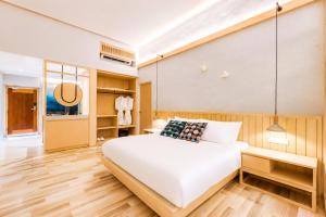 a bedroom with a large white bed and wooden floors at Tien Hotel Georgetown in George Town +37 photos