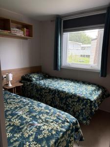 a hotel room with two beds and a window at MysavinaHouse mobilhome 4 à 6 pers camping 4 Etoiles in Piriac-sur-Mer +47 photos