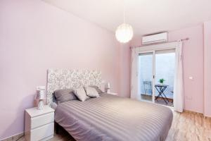 a white bedroom with a large bed and a window at Doña Elena in Fuengirola