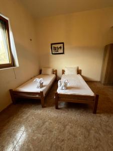 two beds sitting in a room with a window at Obala Ineks in Sutomore