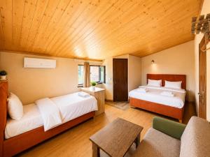 ein Zimmer mit zwei Betten, einer Couch und einem Tisch in der Unterkunft Hotel Prime in Mzcheta
