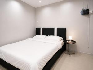 a bedroom with a large white bed and a side table at UMii Homestay in Tawau