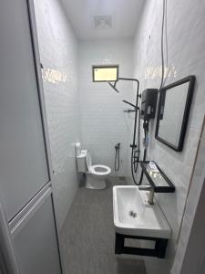 a white bathroom with a sink and a toilet at HomestayDino in Kuala Terengganu
